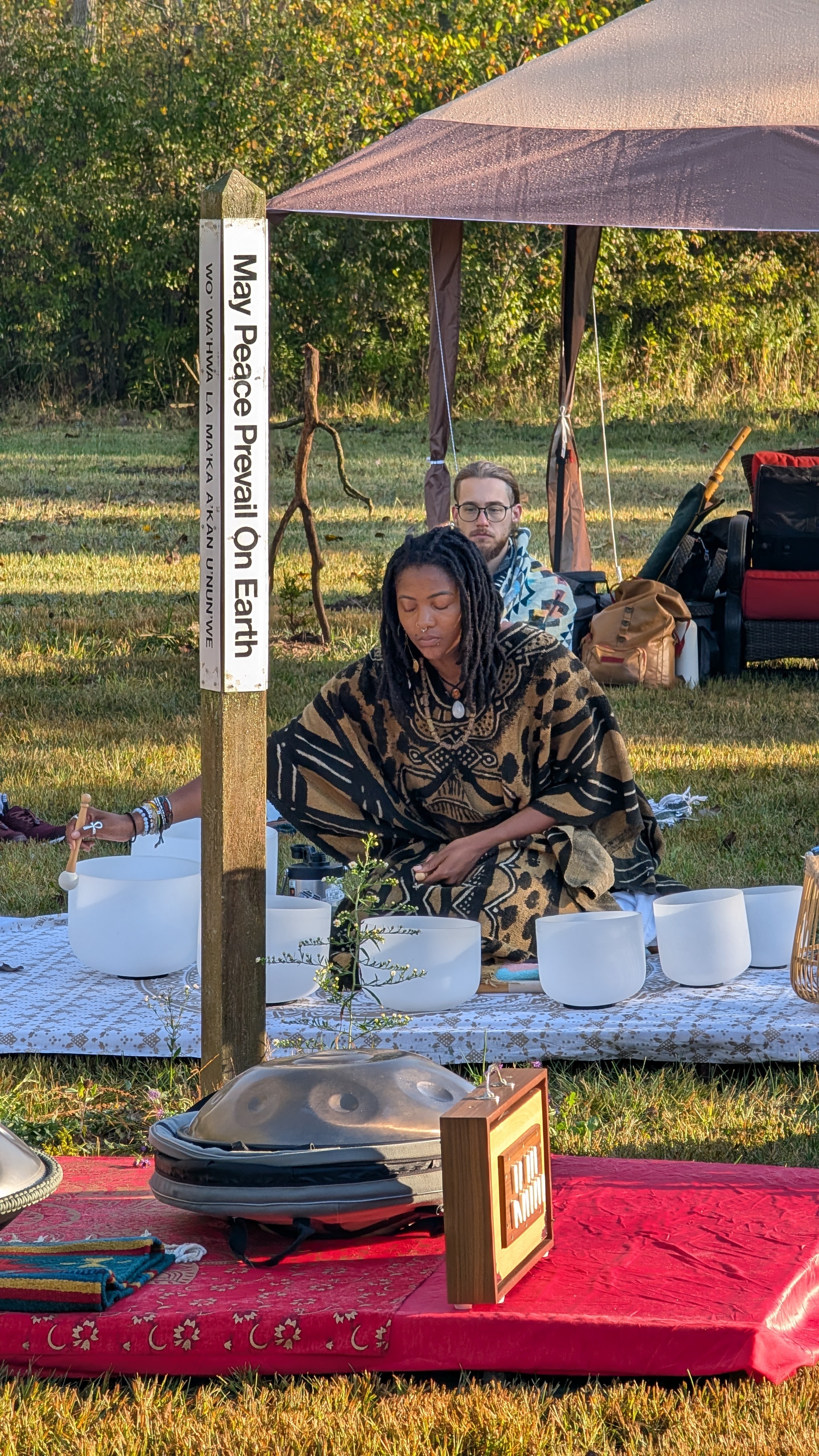 A meditation guide seated among singing bowls