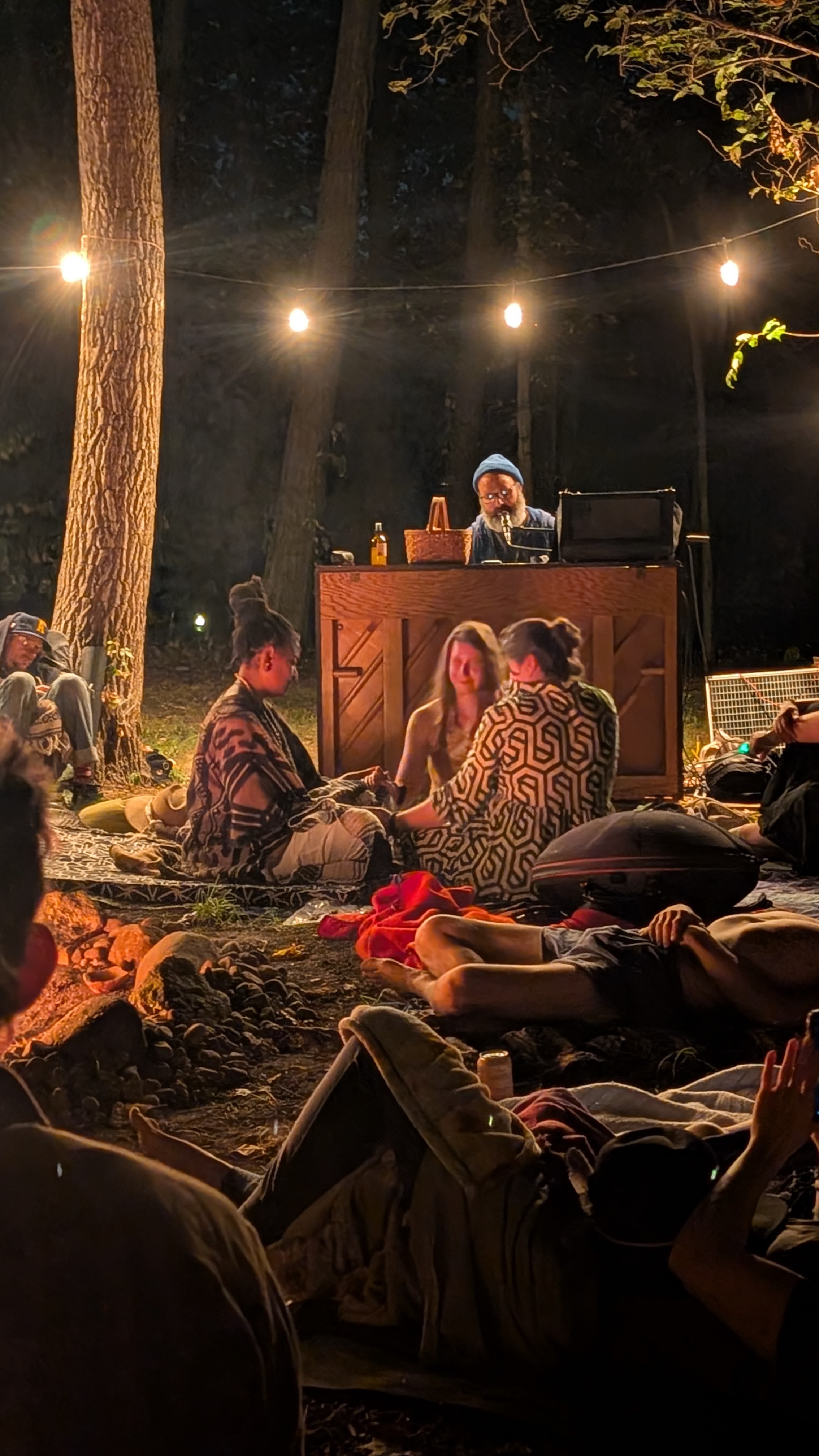 Guests resting around a glowing fire during the nighttime ceremony