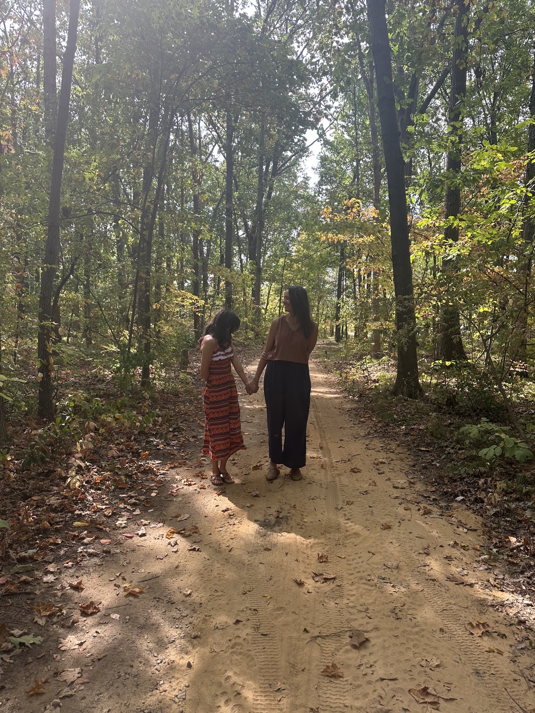 Two guests walking hand in hand along a woodland path